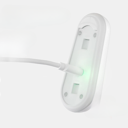 White wall-mounted electrical outlet with a green light on a white background