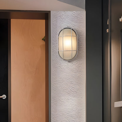 Wall-mounted light fixture on a textured wall next to a wooden door.